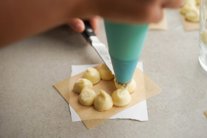 cutting piped dough with knife