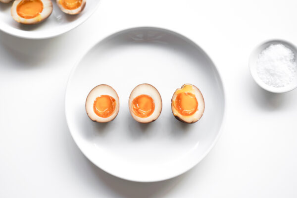 a plate of sliced, marinated ramen eggs, ready to eat!