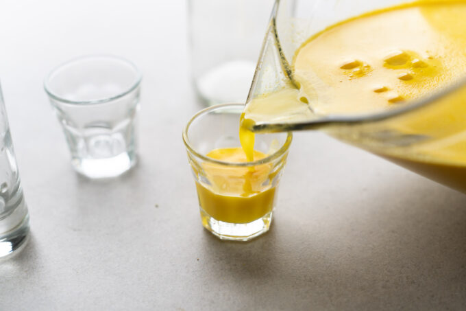 pouring ginger shot into glass