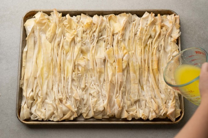 pouring butter over baked phyllo dough