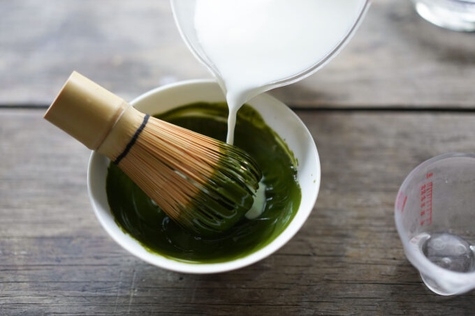 pouring milk into frothed matcha powder