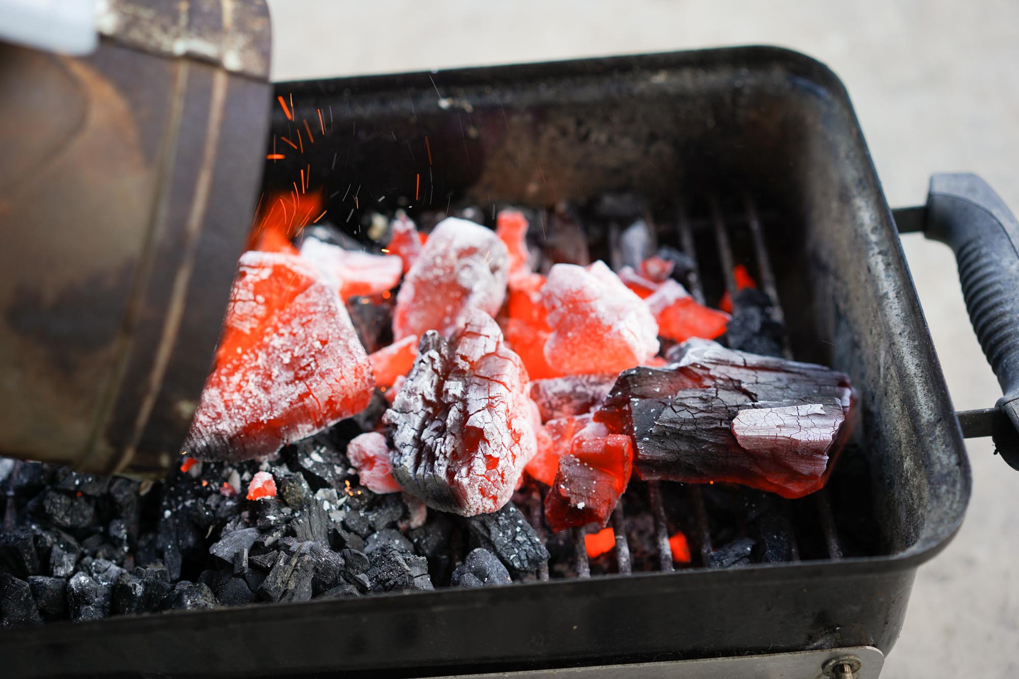 pouring out lit charcoal from chimney starter