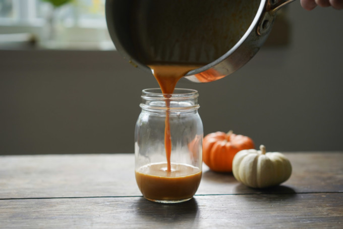 pouring pumpkin sauce into glass jar