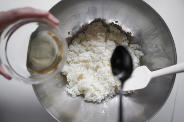 pouring vinegar mixture into the rice, slowly