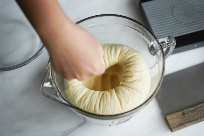 punching dough down to remove gas