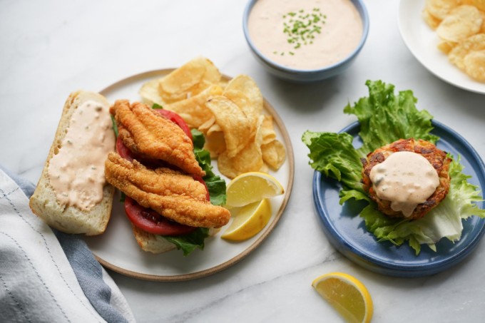plate of catfish poboy and crab cake with remoulade spread on top