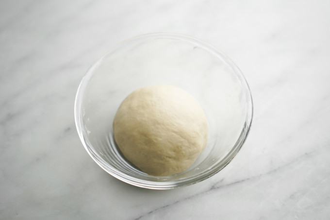 resting dough ball in glass bowl