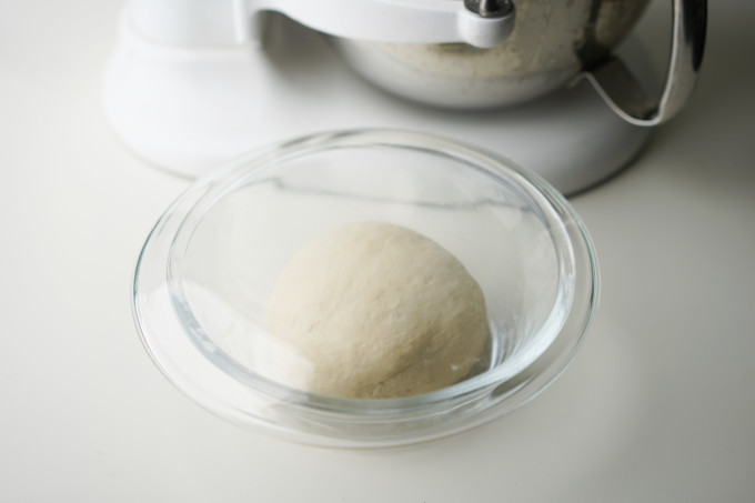 resting dough in a covered glass bowl