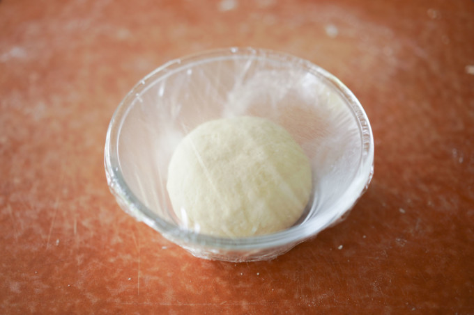 resting dough covered with plastic wrap