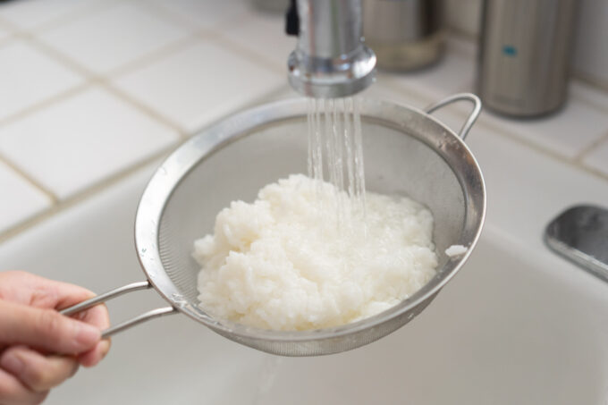 rinsing out mushy rice in the sink