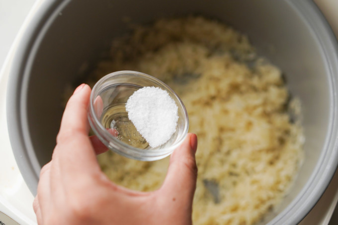 adding salt to rice pot