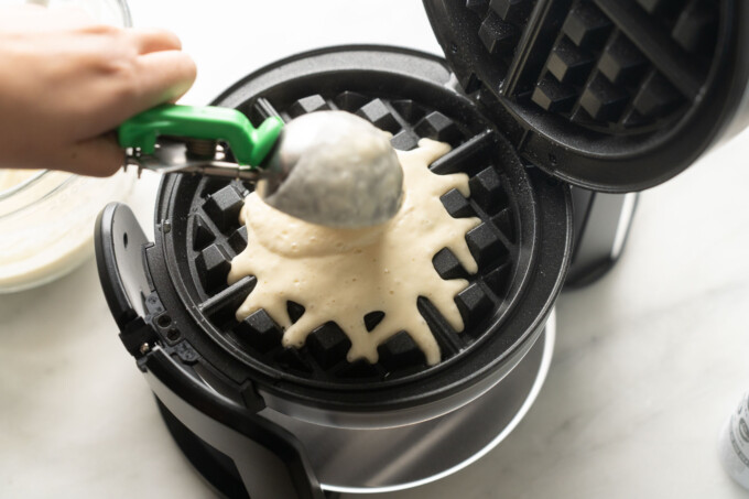 scooping waffle batter onto waffle iron