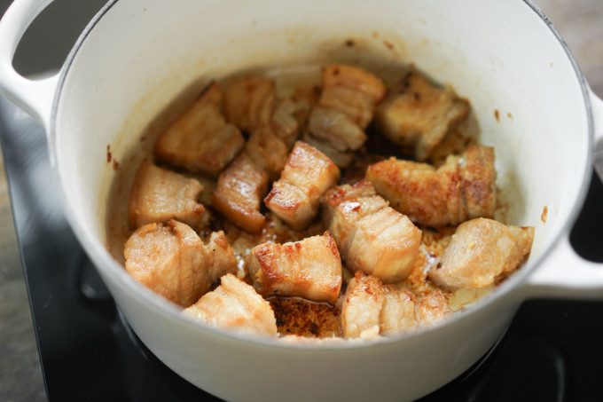 searing pork belly in a cast iron pot