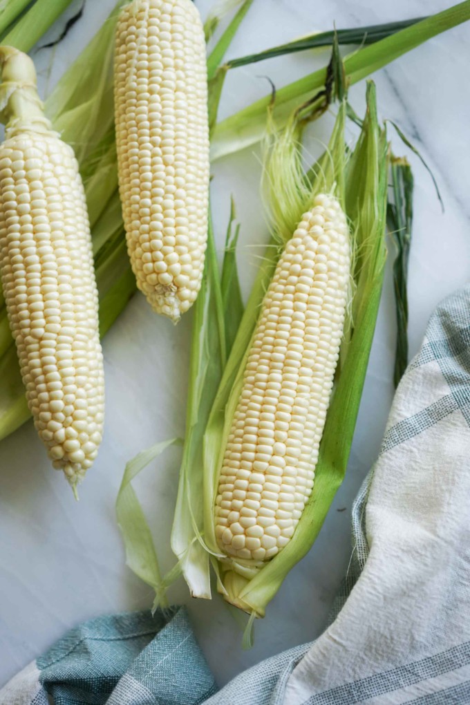three ears of shucked corn