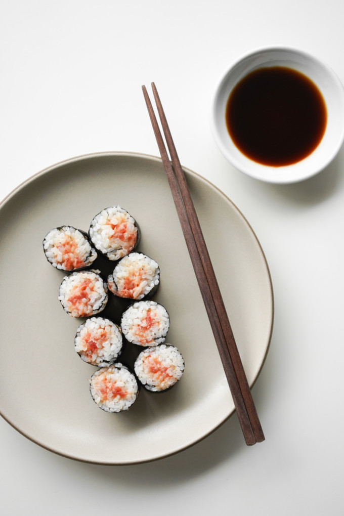 overhead view of cut spicy tuna rolls with soy sauce