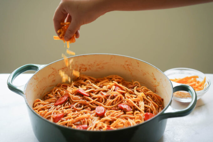 sprinkling cheese onto the pot