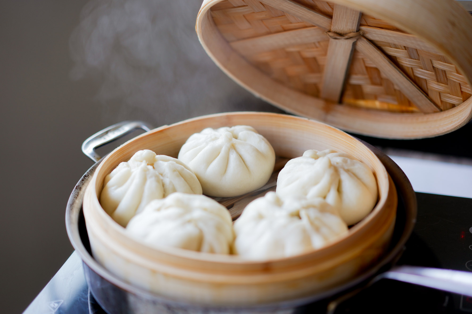 char siu bao in a bamboo steamer