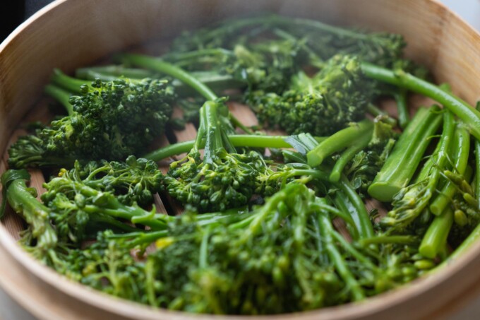 steaming broccolini in a steamer basket