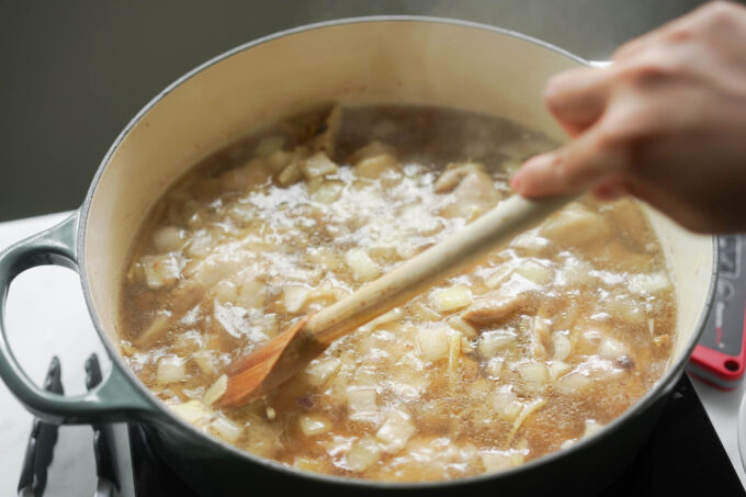 stirring the pot of chicken tinola