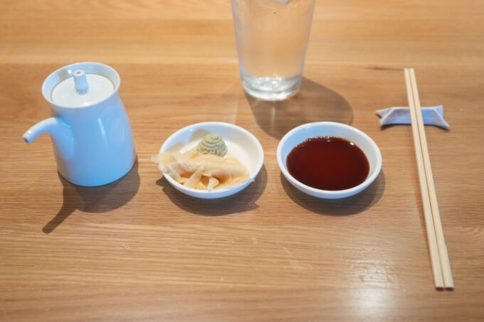 sushi plate setting: soy sauce, ginger and wasabi, soy sauce, chopsticks