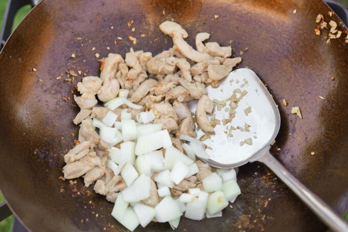 adding onions to the wok