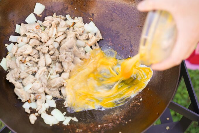 adding eggs to wok