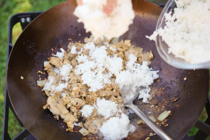 adding rice to wok