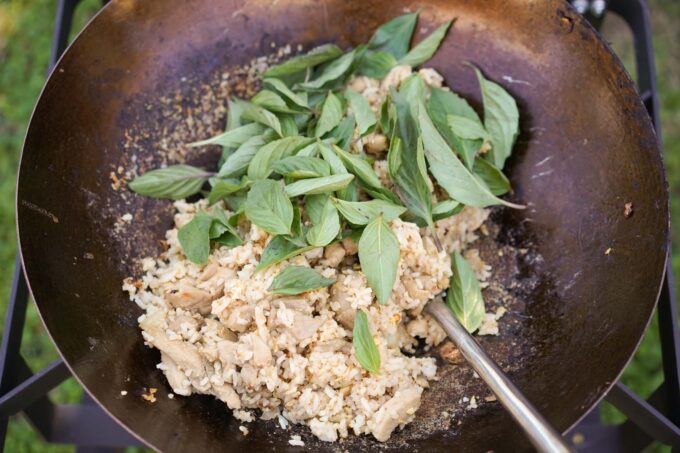 adding Thai basil to wok