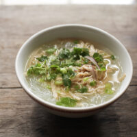 bowl of Vietnamese mien ga with sprig of cilantro nearby