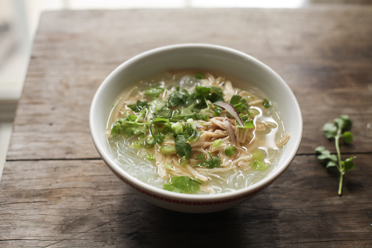 bowl of Vietnamese mien ga with sprig of cilantro nearby